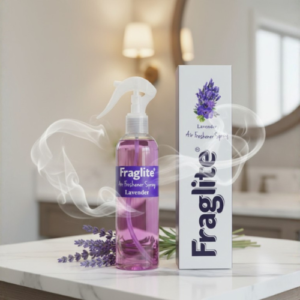 A purple Fraglite lavender spray bottle and white box on a marble countertop in a blurred bathroom setting with lavender sprigs.