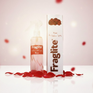 A Fraglite Rose air freshener bottle and box centered against a soft pink background with falling red rose petals.