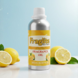 A Fraglite Lemon Fragrance Oil aluminum bottle standing on a white surface with fresh whole and halved lemons against a soft blue background.