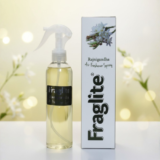 A Fraglite Rajnigandha spray bottle and box set against a soft, glowing background with white tuberose flowers.