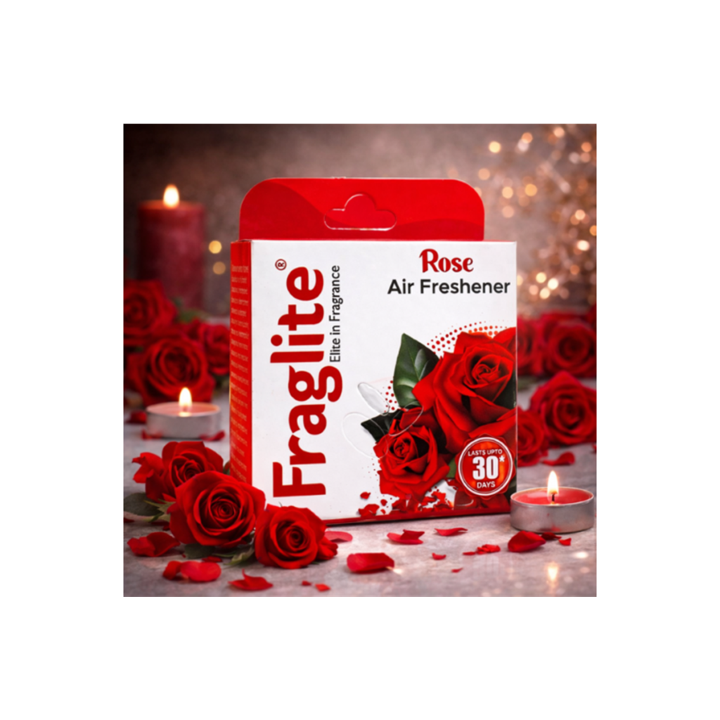 A box of Fraglite Rose Air Freshener placed among red roses and lit tea light candles in a warm, dimly lit environment.