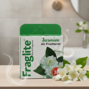 A box of Fraglite Jasmine Air Freshener sitting on a wooden surface next to fresh white jasmine flowers in a bright bathroom setting.