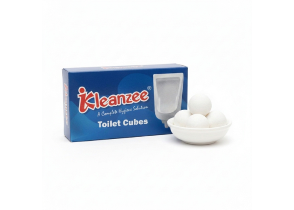 A blue box of Kleanzee Toilet Cubes featuring a urinal illustration, placed next to a small white bowl containing four white spherical toilet cubes.